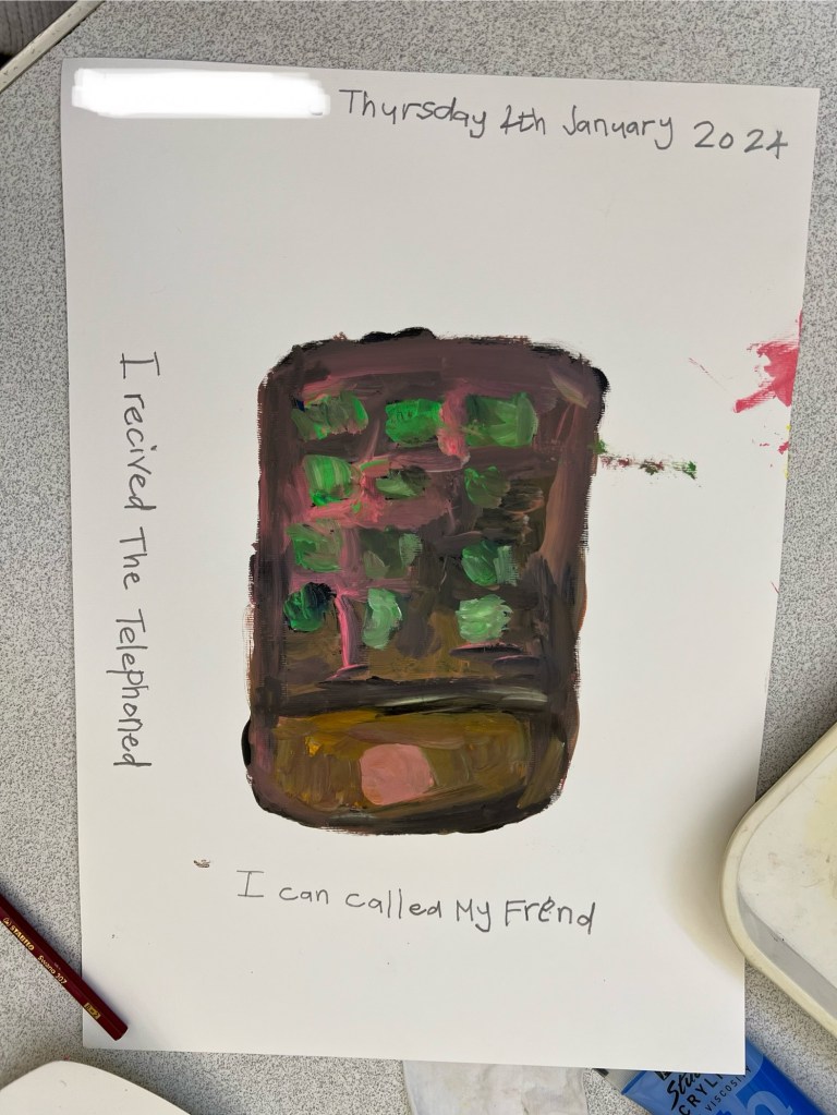 painting of a phone. It is orange-y brown with green buttons- surrounding it is writing saying I received the telephone I can call my friends.