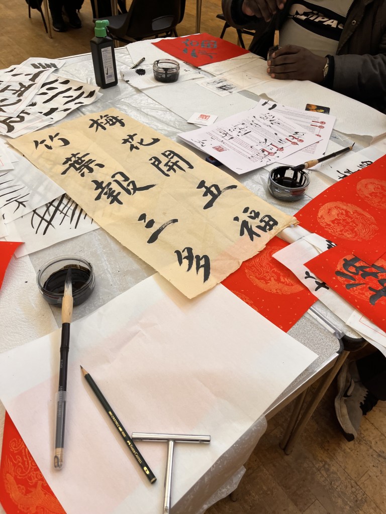 Examples of Chinese symbols on table and many participants work.