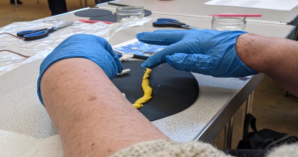 Someone arranging tissue paper to create the starry night.