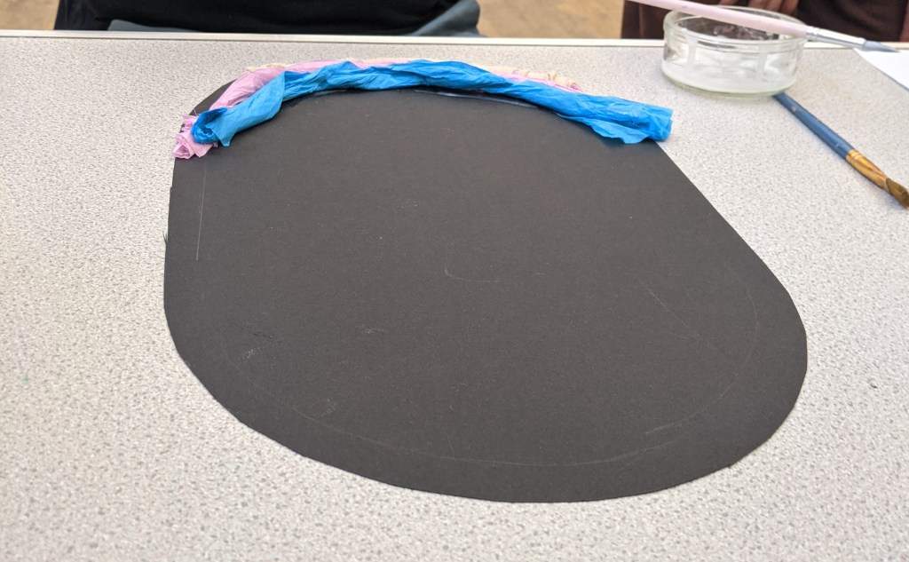 Blue tissue paper on black circular paper.