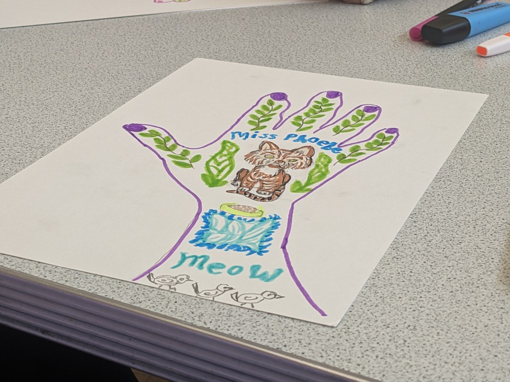 Purple outline of hand, various plants painted inside as well as a brown tabby cat. Word Meow appears two times.