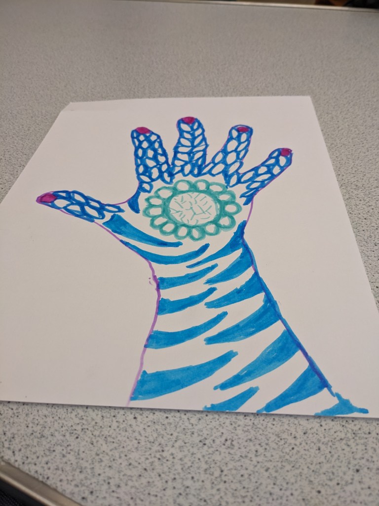 Paper hand with blue swirls and teal flower in middle of palm.