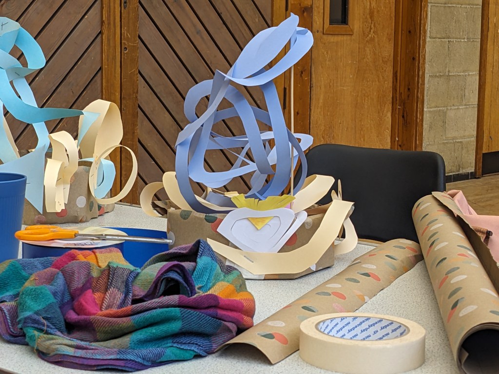 Cardboard and card hat with huge yellow and blue swirls attached.