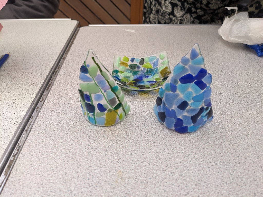 image of two tealights and a coaster. the coaster has green tones as does one of the tealights. The other tealight uses multiple blue ones instead.