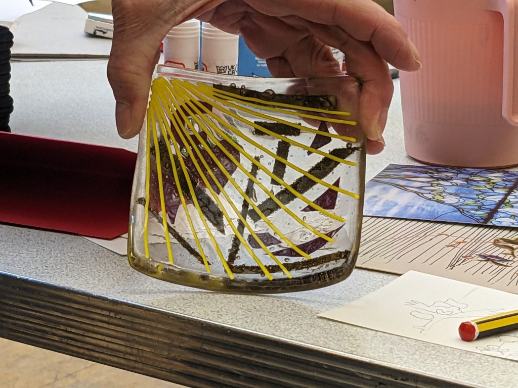 Coaster which has a yellow sun with rays going diagonally to next corner