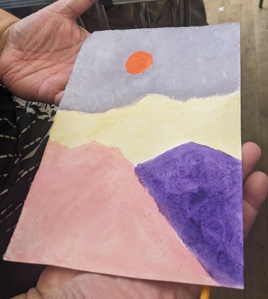three line landscape. has a orange Sun lavender sky yellow mountains and coral and purple bottom.