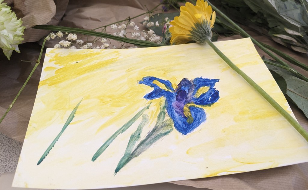 Blue Flower with green stems and leaves on a yellow background. In the corner is a Daffodil and in the upper centre are some white flowers. 