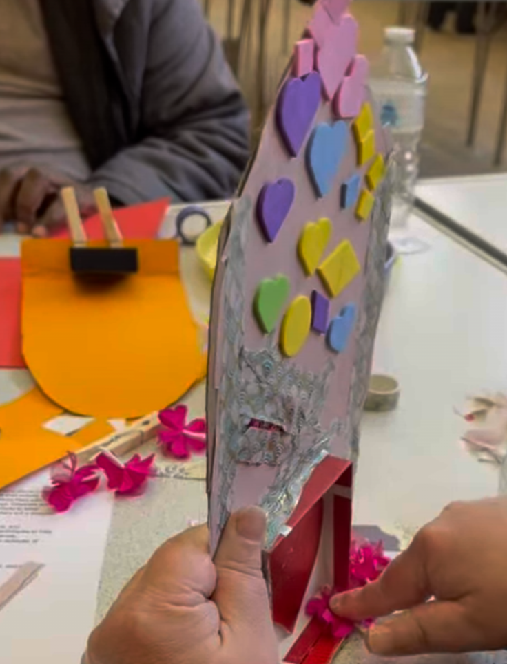 Heart Shrine Box 4: Base is a light pink with ribbons on it are yellow, blue, purple and light green shapes such as: Hearts, Circles and Diamonds. The second box is red with a red shape inside it. 