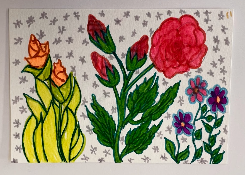 Mixture of red, pink and orange roses with green stems and leaves on a silver starry background.